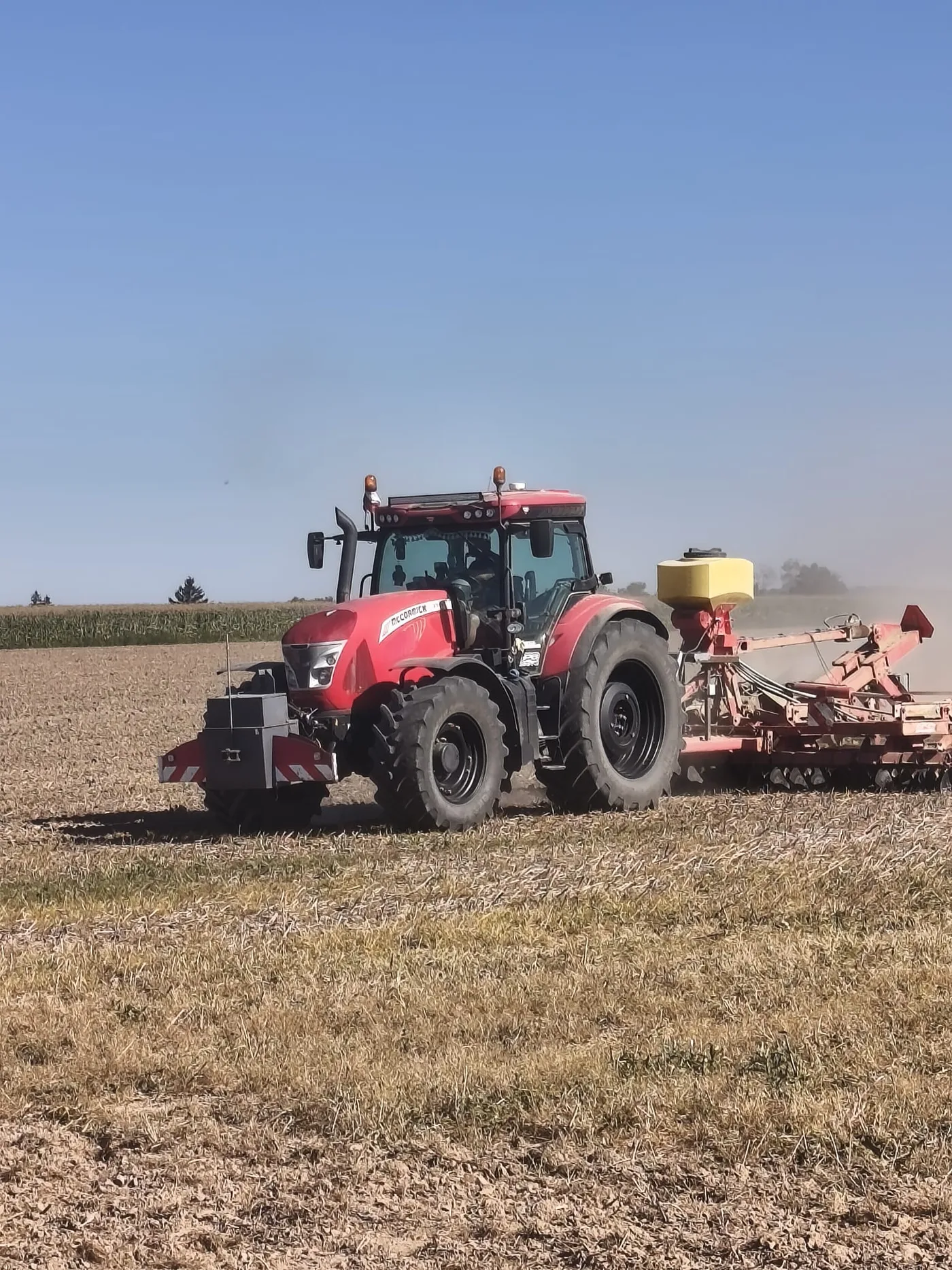Traktor McCormick se secím strojem na poli